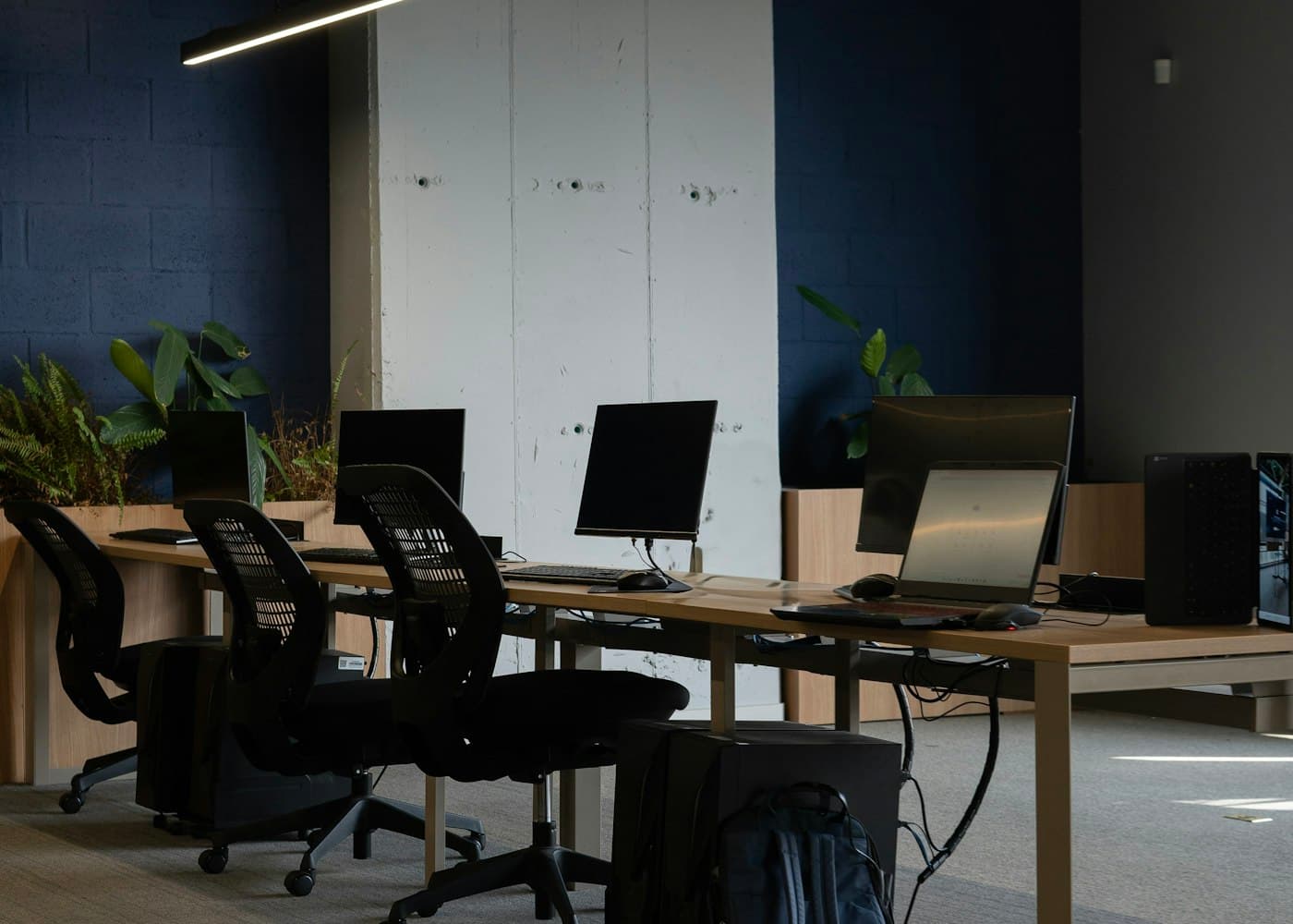 Row of modular workstations with monitors and task chairs